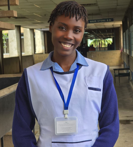 A nurse in uniform smiling in a hospital walkway